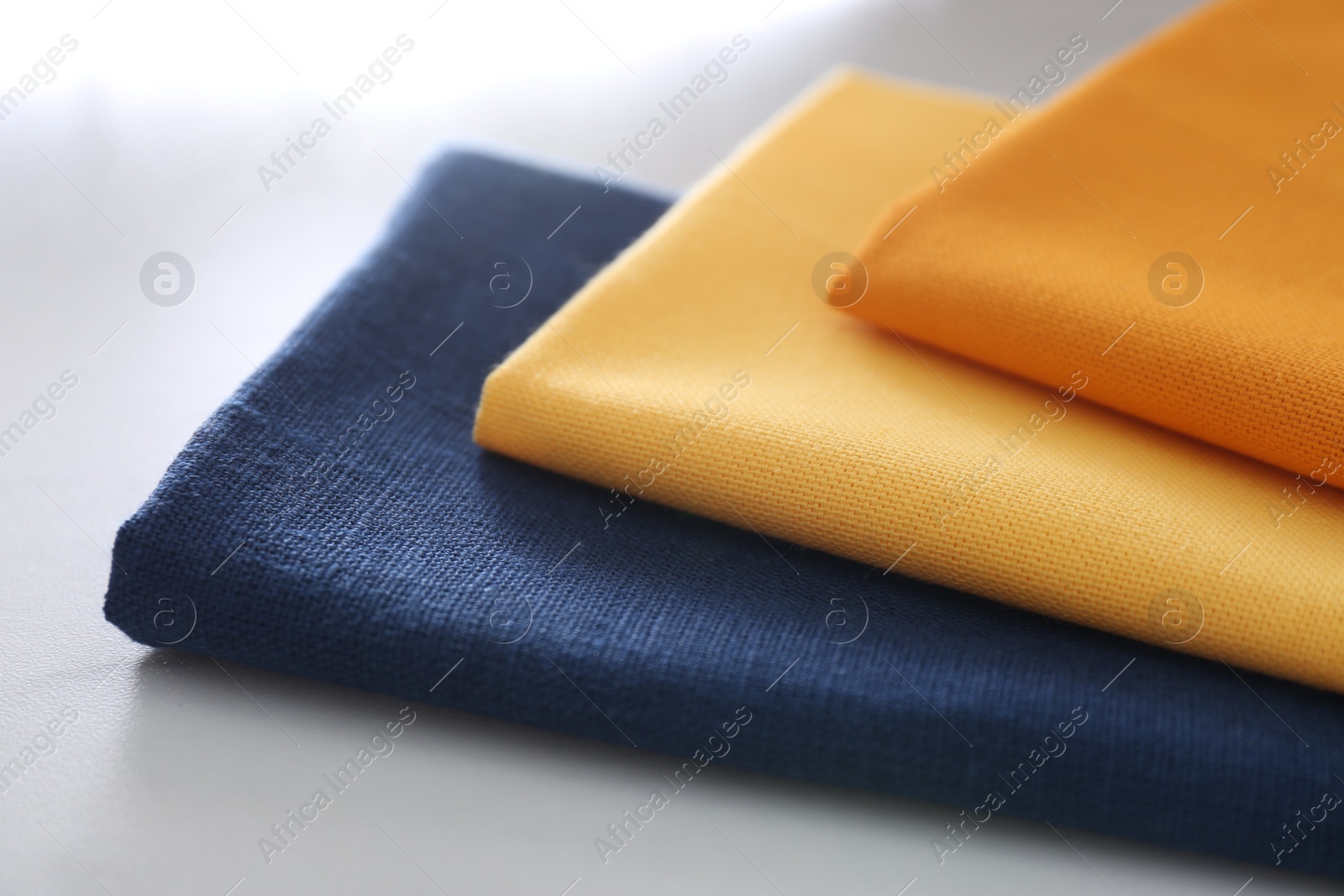 Photo of Different colorful napkins on white table, closeup