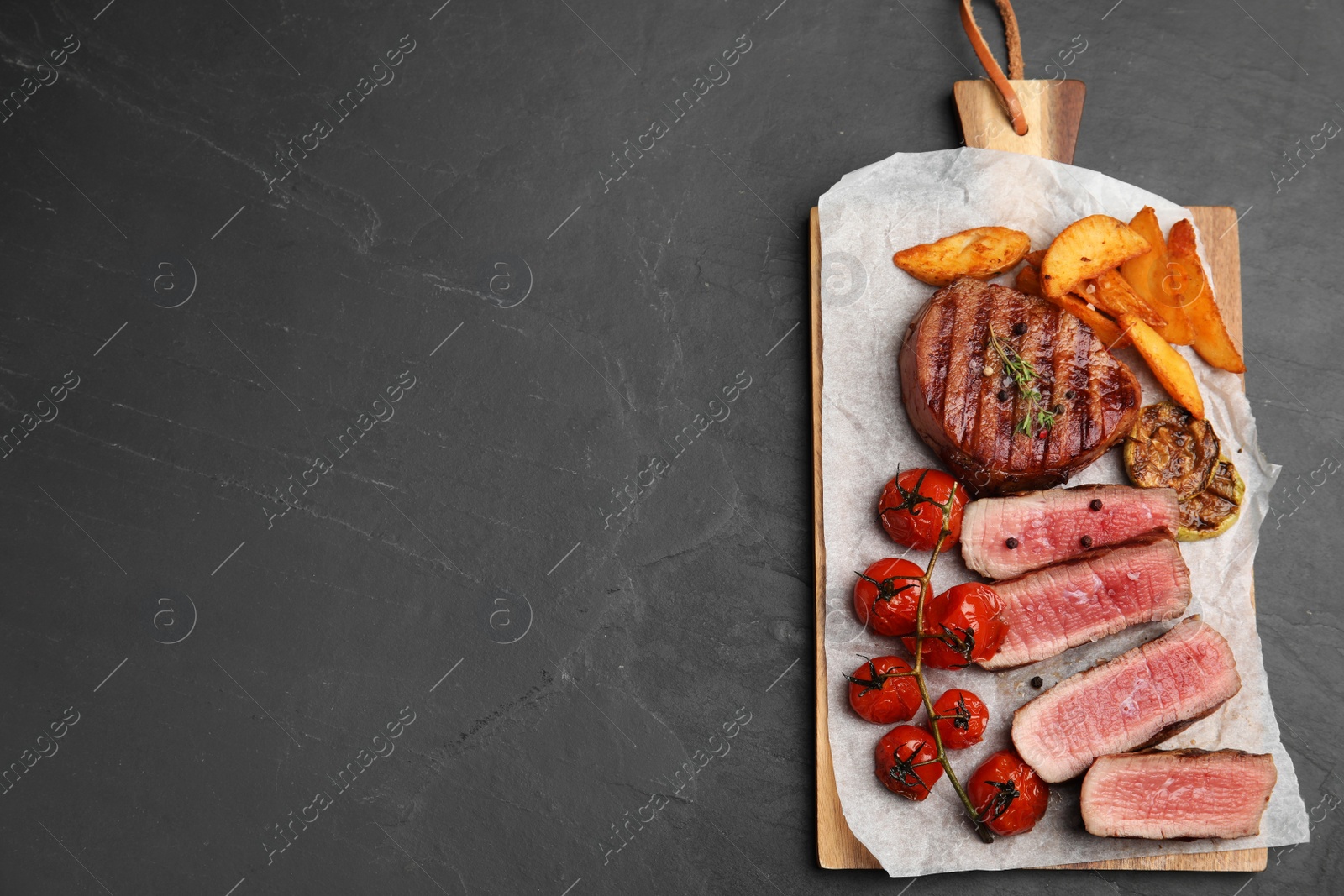 Photo of Delicious beef served on black table, top view. Space for text