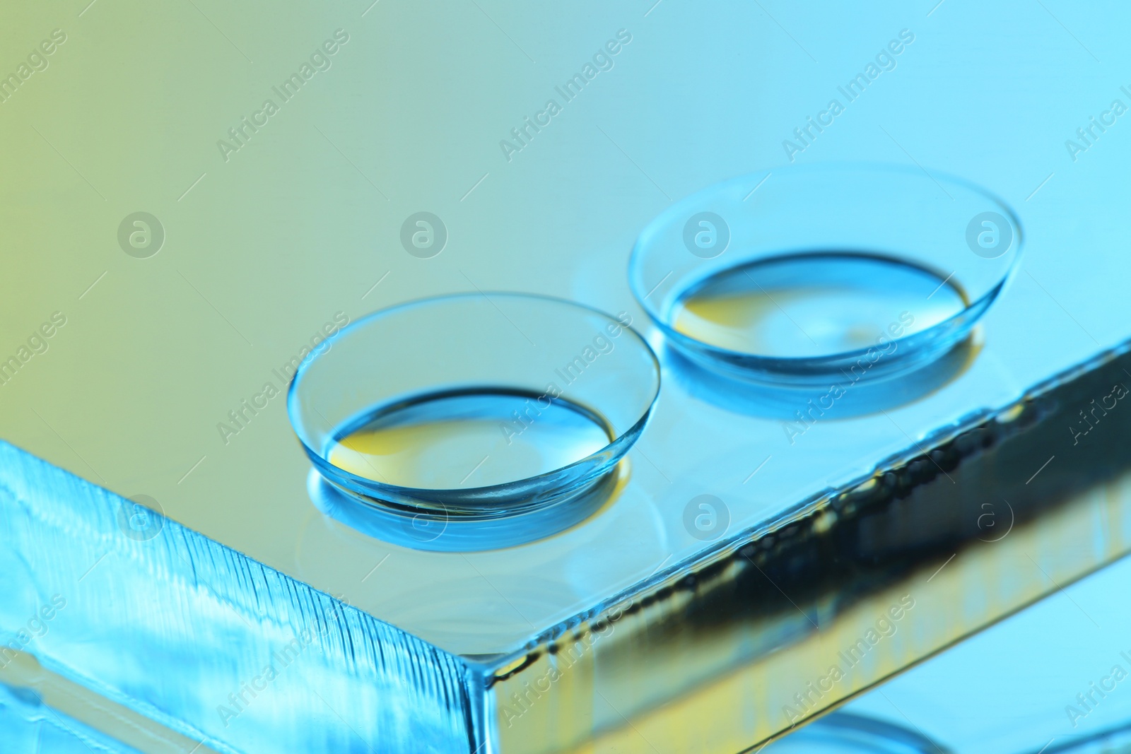 Photo of Pair of contact lenses on mirror surface, closeup