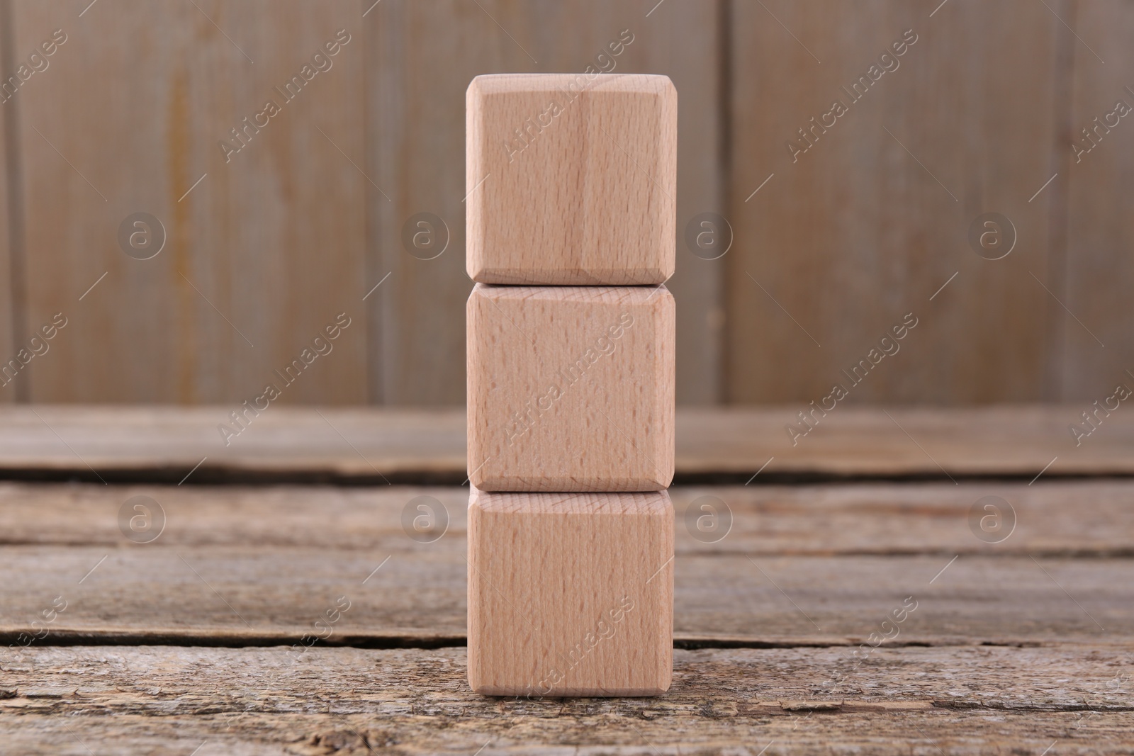 Photo of Stack of empty cubes on wooden table, space for text