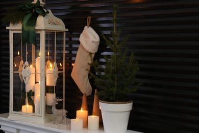 Photo of Decorative lantern and Christmas decor on shelf indoors