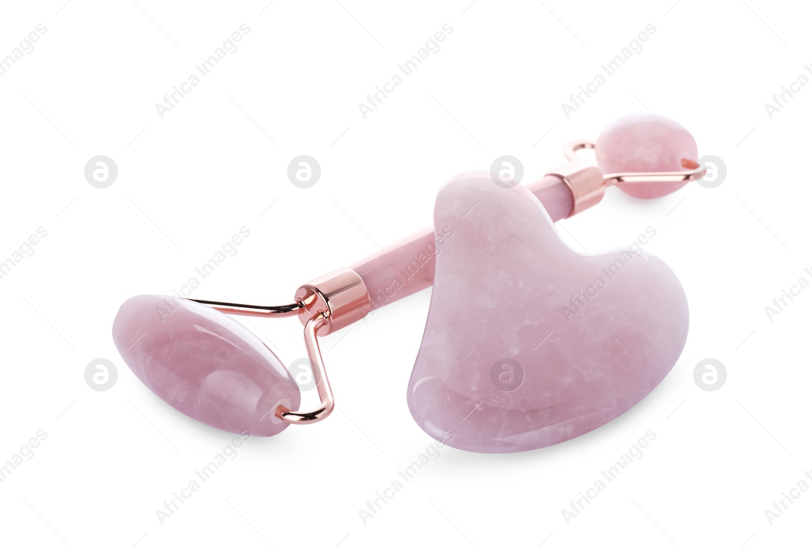 Photo of Rose quartz gua sha tool and facial roller isolated on white