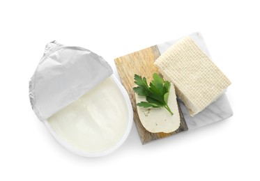 Photo of Tasty tofu, cream cheese and parsley leaf on white background, top view