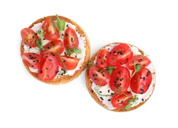 Photo of Tasty rusks with cream cheese, fresh tomatoes and black sesame seeds isolated on white, top view