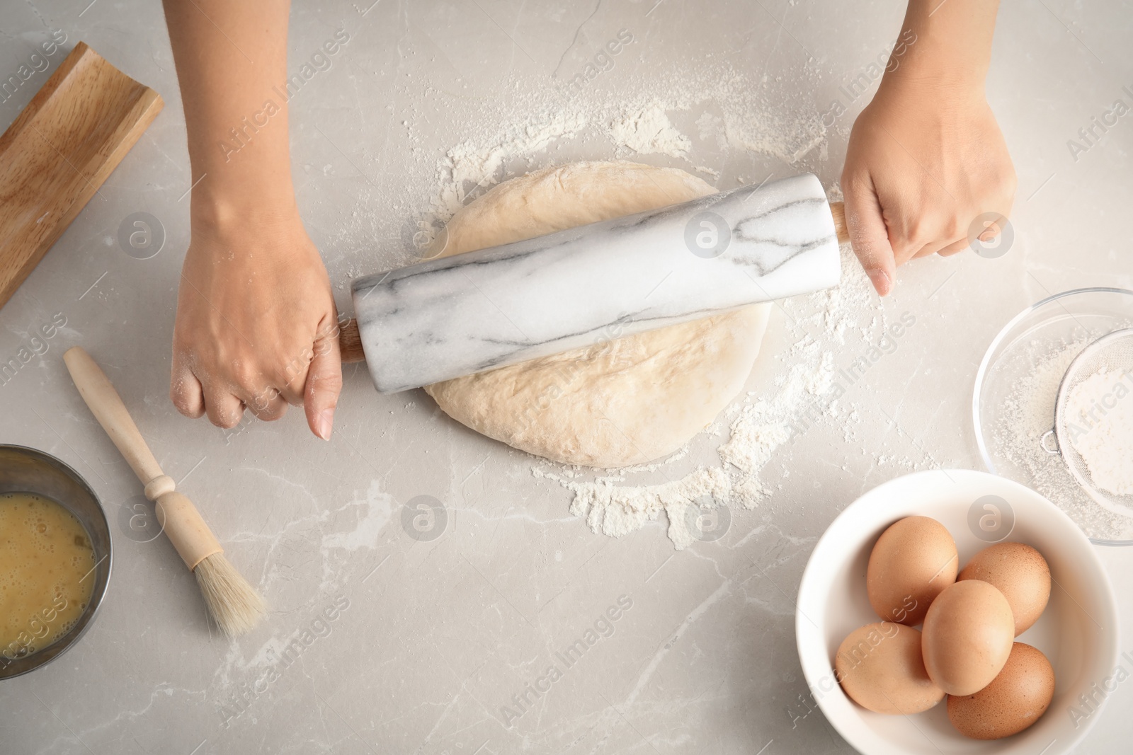 Photo of Woman rolling dough for pastry on table