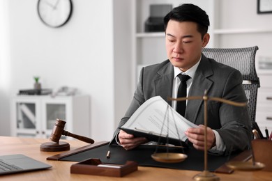Notary working at wooden table in office, space for text