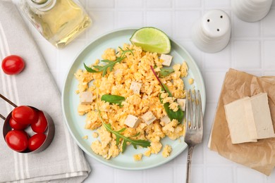 Photo of Delicious scrambled eggs with tofu and lime served on white table, flat lay