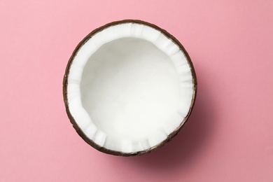 Photo of Fresh coconut half on pink background, top view