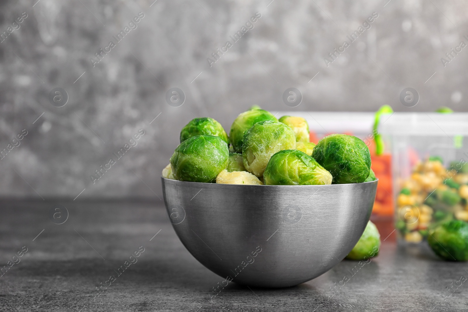 Photo of Bowl with frozen Brussel sprouts on table. Vegetable preservation