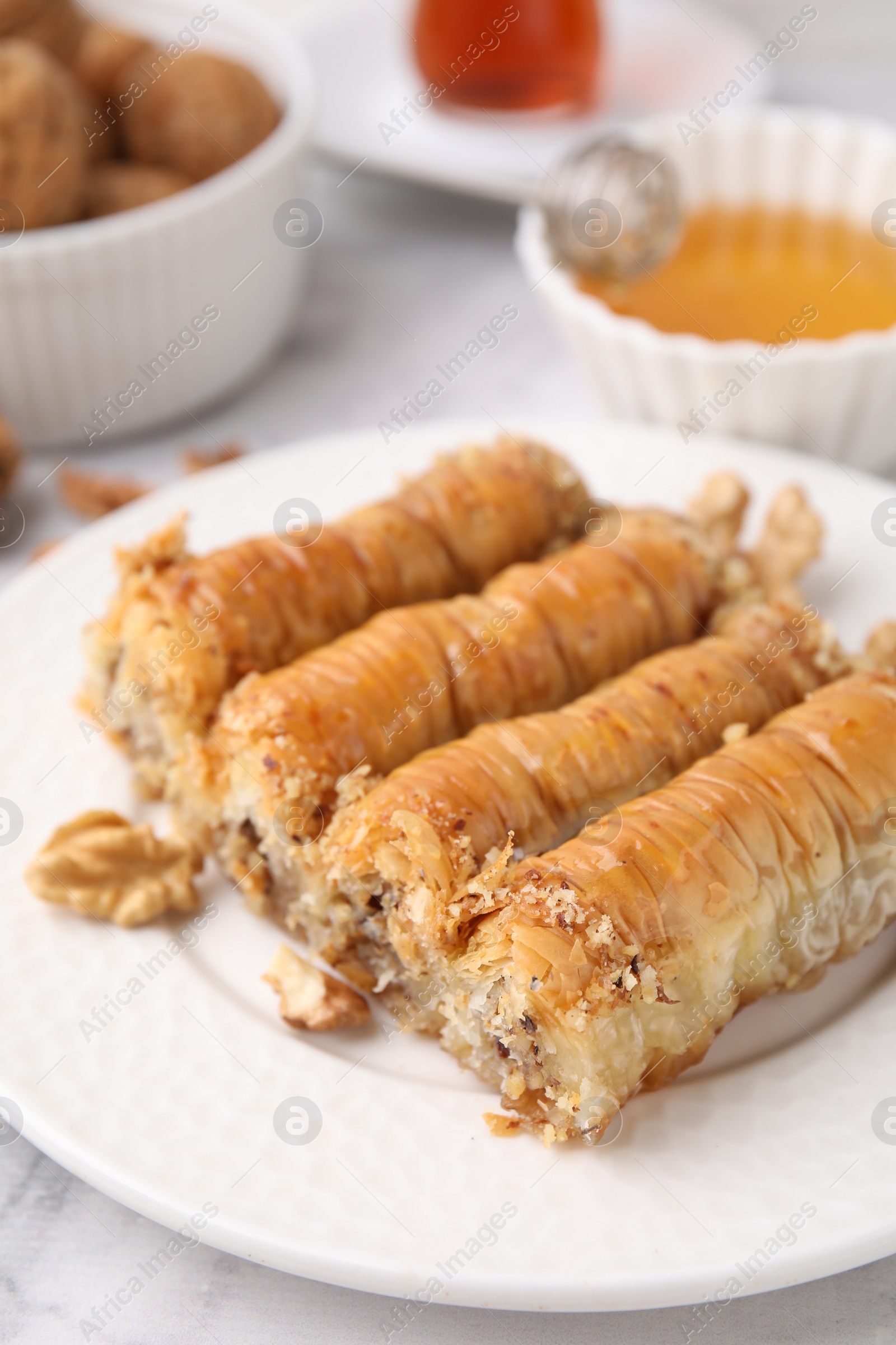 Photo of Eastern sweets. Pieces of tasty baklava on white marble table, closeup