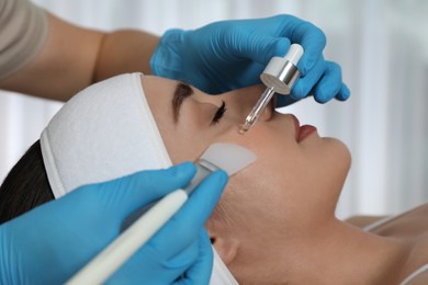 Young woman during face peeling procedure in salon, closeup