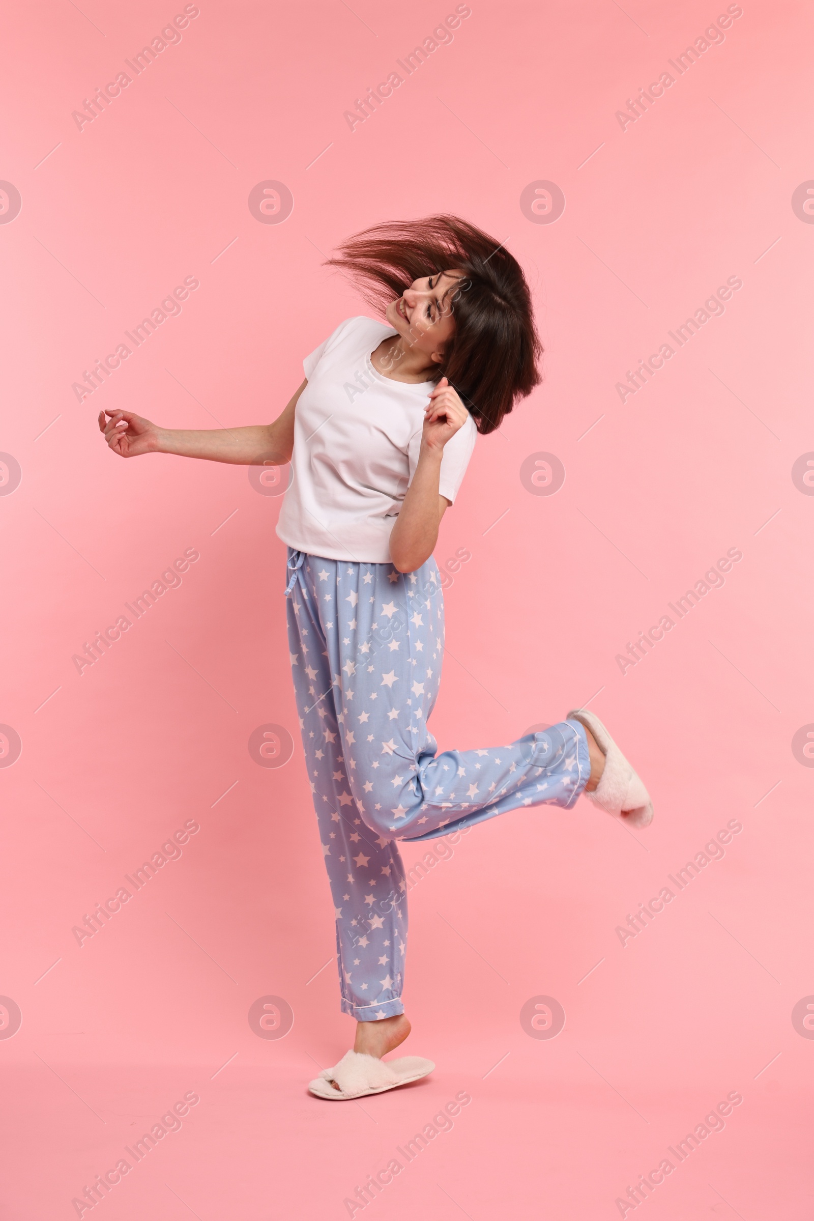 Photo of Happy woman in pyjama shaking head on pink background