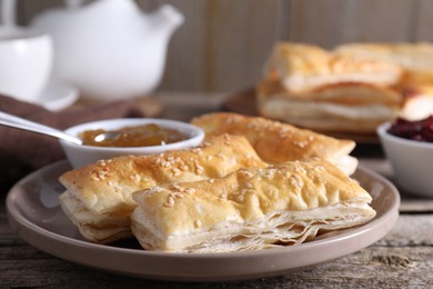 Delicious puff pastry served on wooden table, closeup