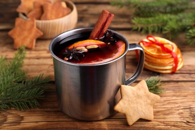 Photo of Aromatic mulled wine and cookie on wooden table