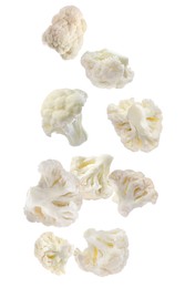 Many fresh cauliflower florets falling on white background