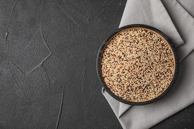 Plate with mixed quinoa seeds and space for text on dark background, top view