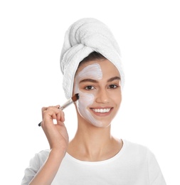 Photo of Happy young woman applying organic mask on her face against white background