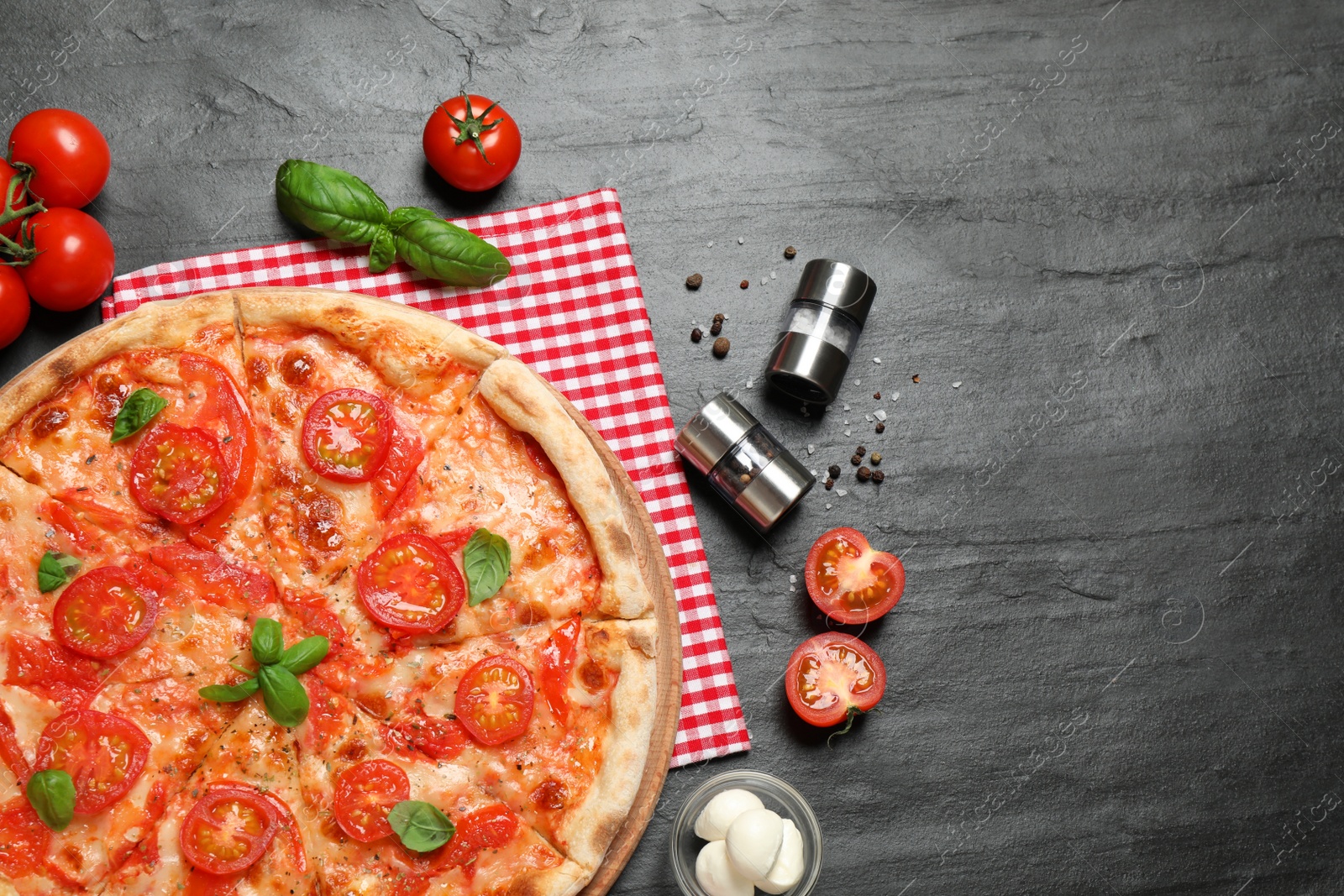 Photo of Delicious pizza Margherita and ingredients on dark grey table, flat lay