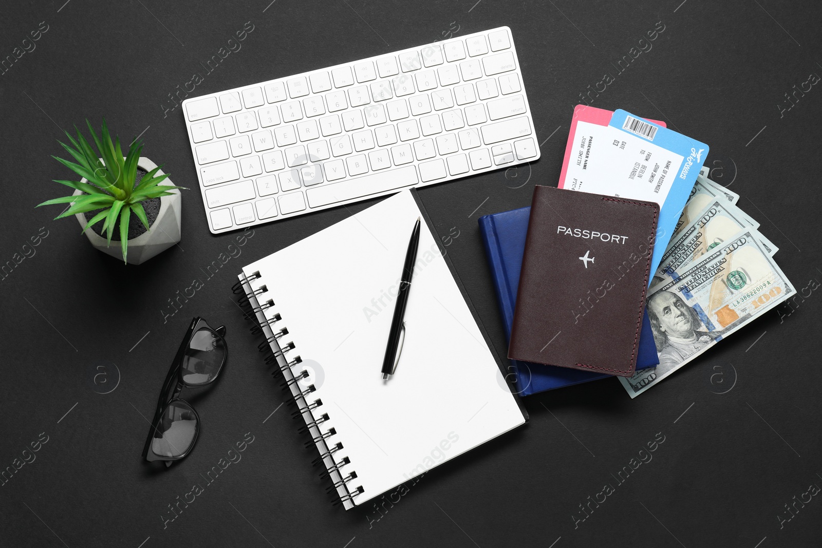 Photo of Flat lay composition with passport, keyboard and dollars on black table. Business trip