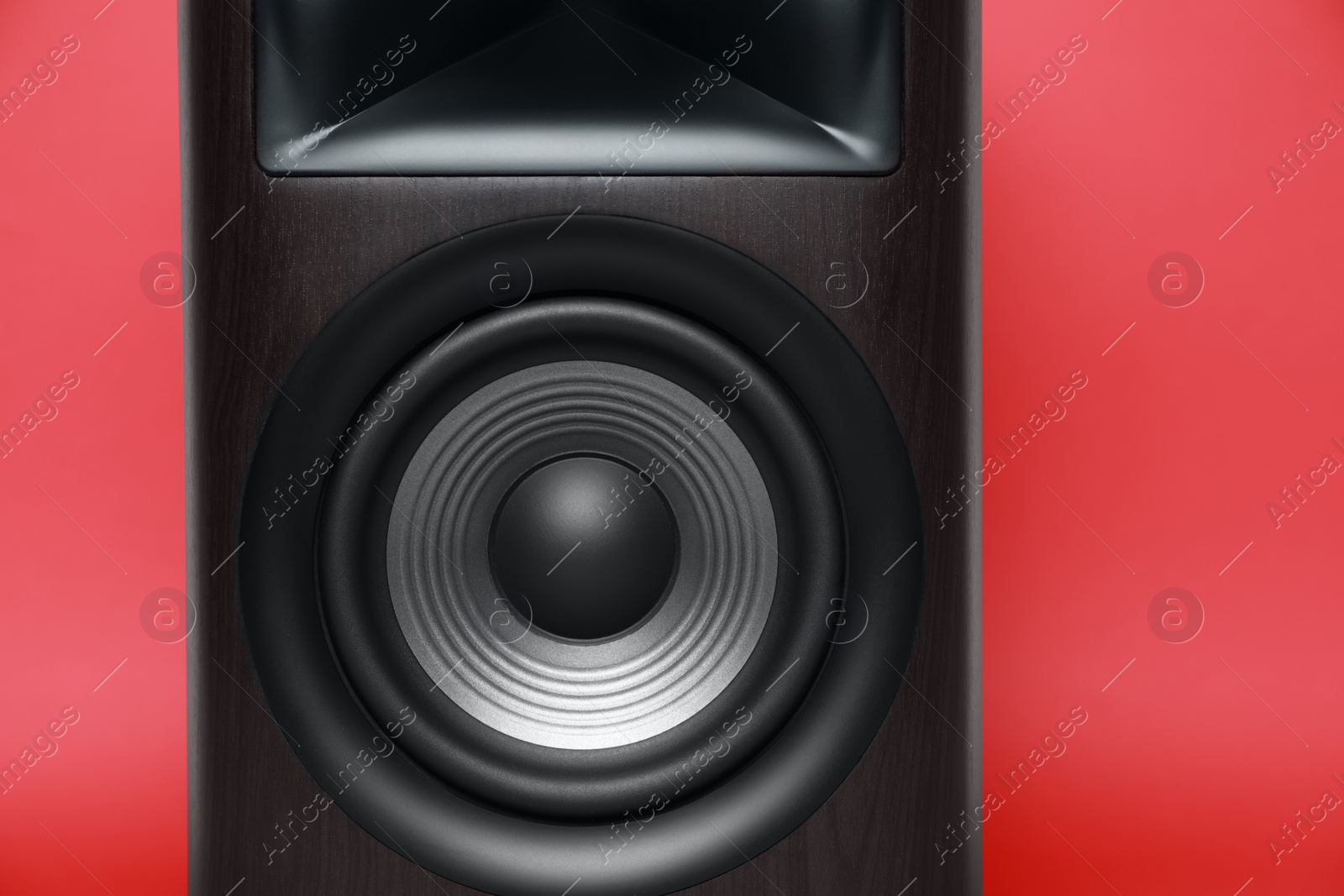 Photo of One wooden sound speaker on red background, closeup