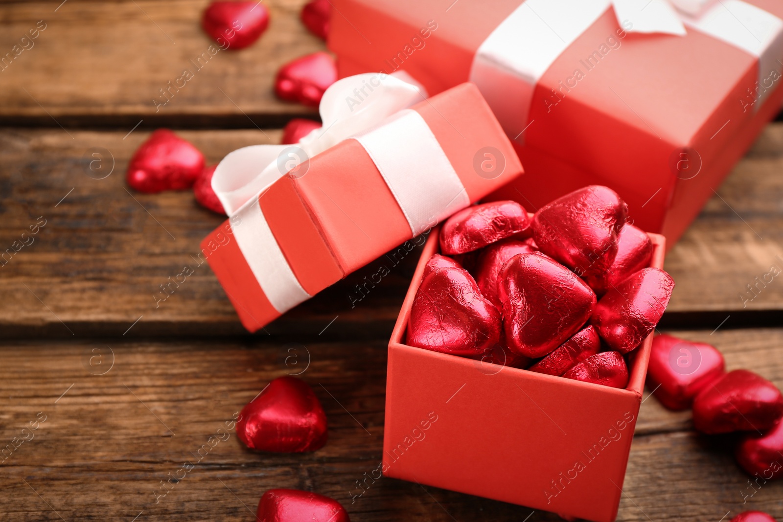 Photo of Box of heart shaped chocolate candies on wooden table