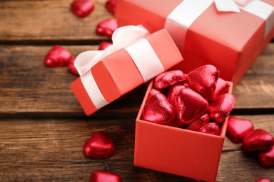 Box of heart shaped chocolate candies on wooden table