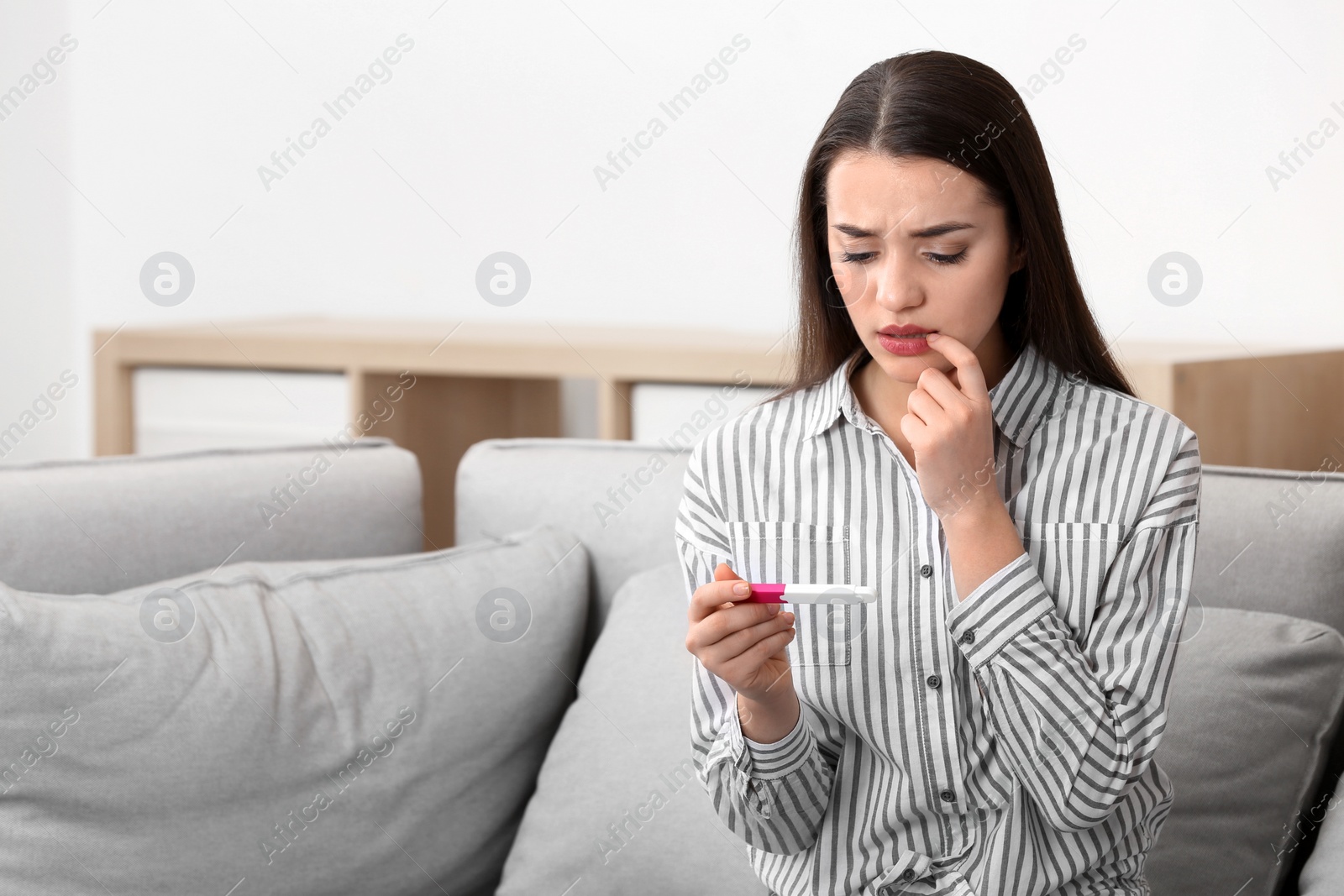 Photo of Young woman with pregnancy test at home. Gynecology and childbirth