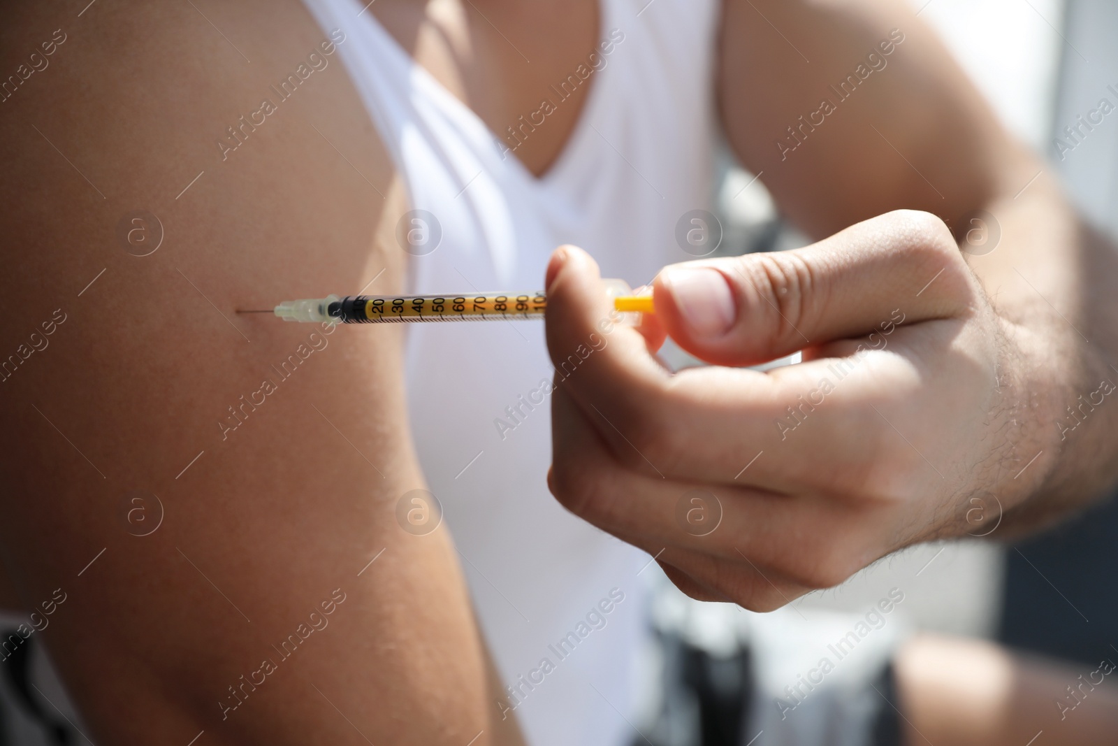Photo of Sportsman injecting himself indoors, closeup. Doping concept