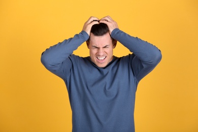 Photo of Portrait of stressed man on yellow background