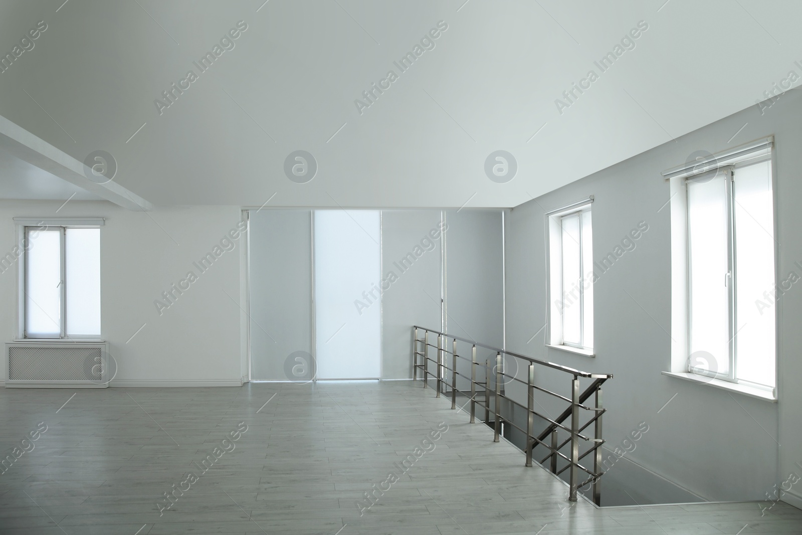 Photo of Large empty hall with windows and railings