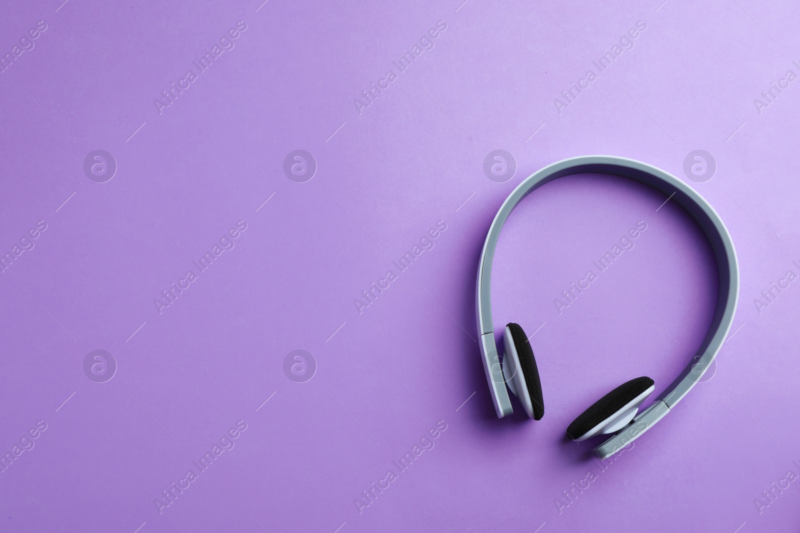 Photo of Wireless headphones on color background, top view. Space for text