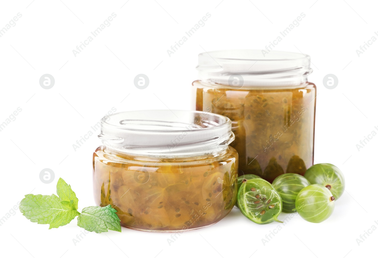 Photo of Jars of delicious gooseberry jam and fresh berries on white background