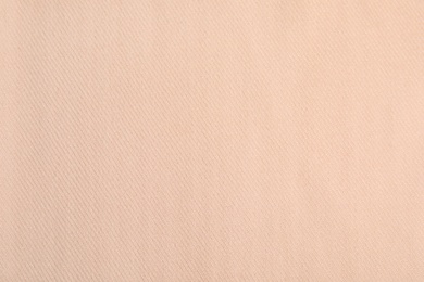 Beige soft cashmere fabric as background, closeup