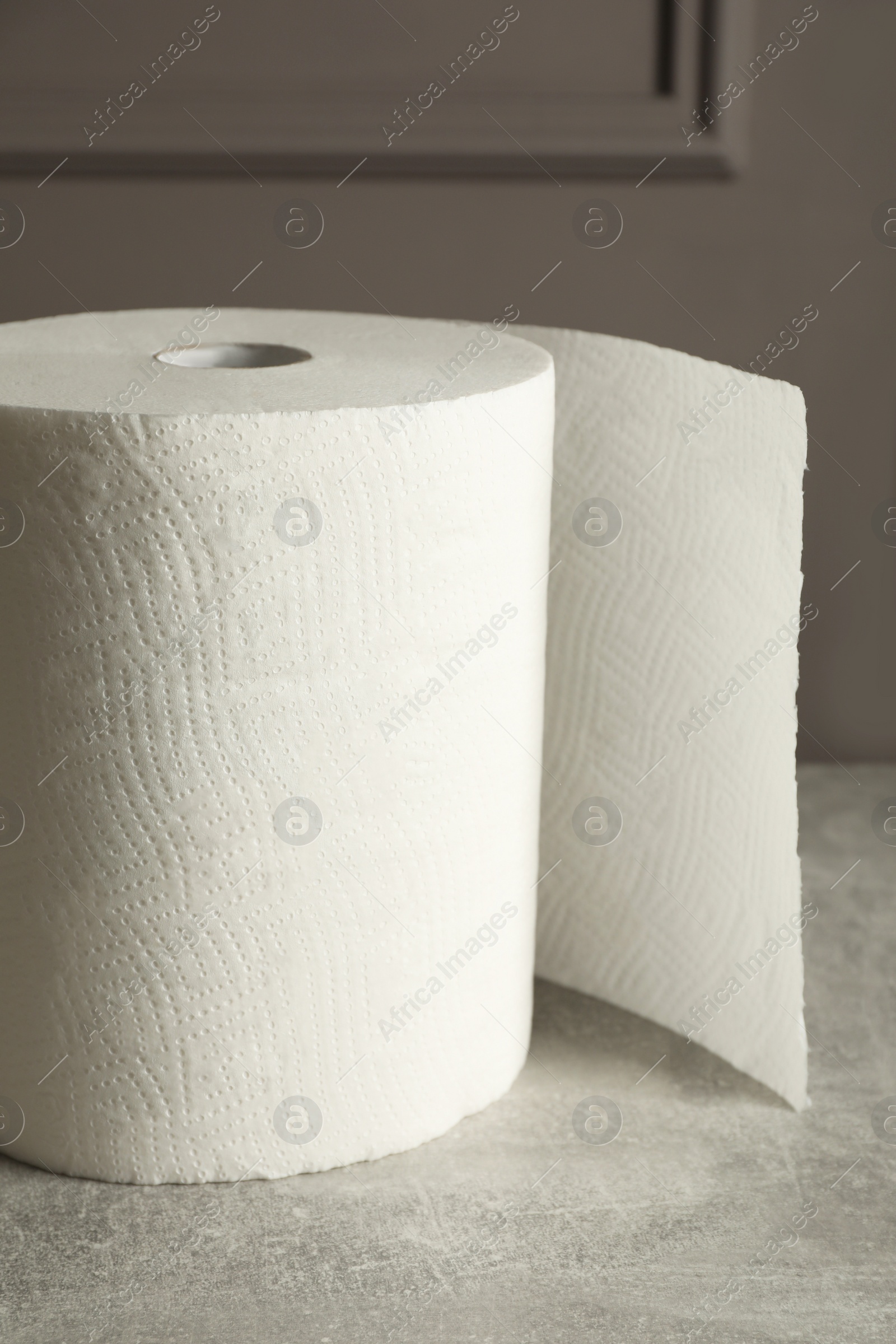 Photo of Roll of white paper towels on grey table