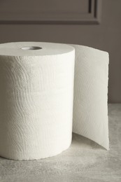 Roll of white paper towels on grey table