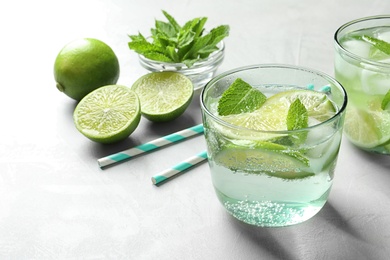 Photo of Refreshing beverage with mint and lime in glass on table