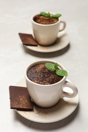 Photo of Cup of delicious hot chocolate with fresh mint on grey table