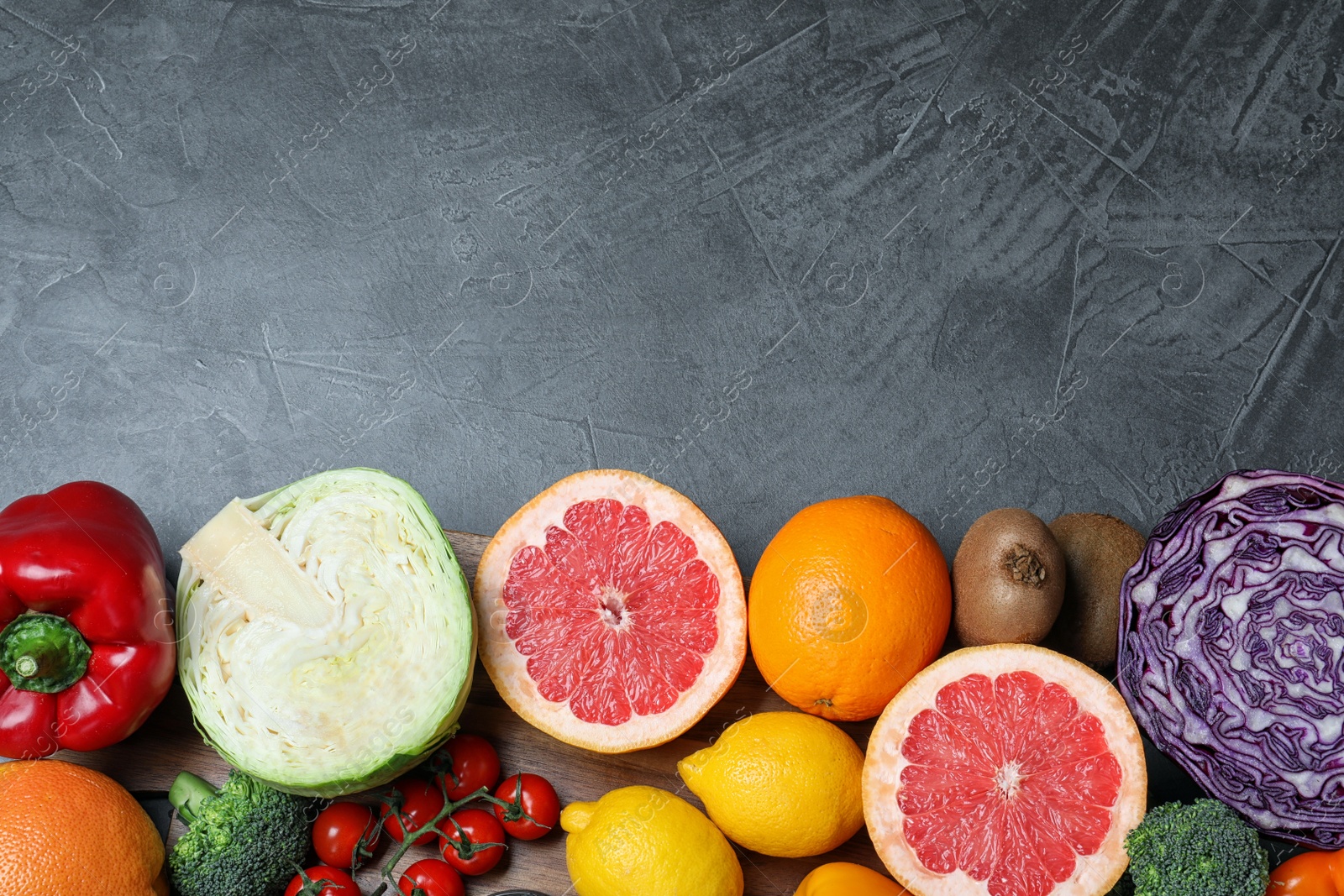 Photo of Different products rich in vitamin C on grey table, flat lay. Space for text