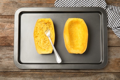 Photo of Baking sheet with cooked spaghetti squash and fork on table, top view