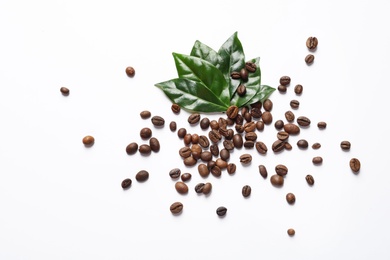Photo of Fresh green coffee leaves and beans on white background, top view