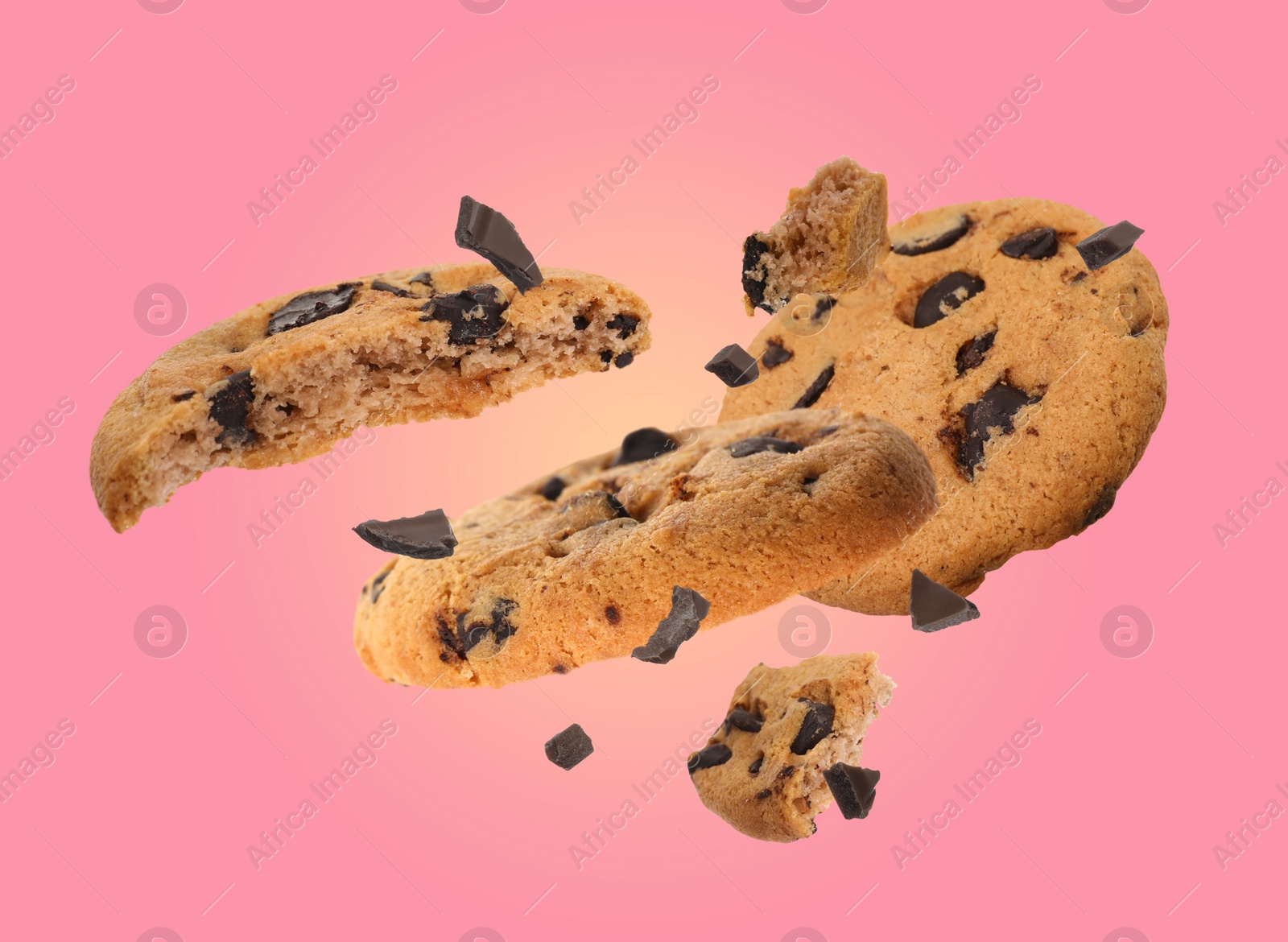 Image of Tasty chocolate chip cookies falling on pink background