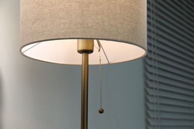 Photo of One stylish lamp near light wall, closeup view