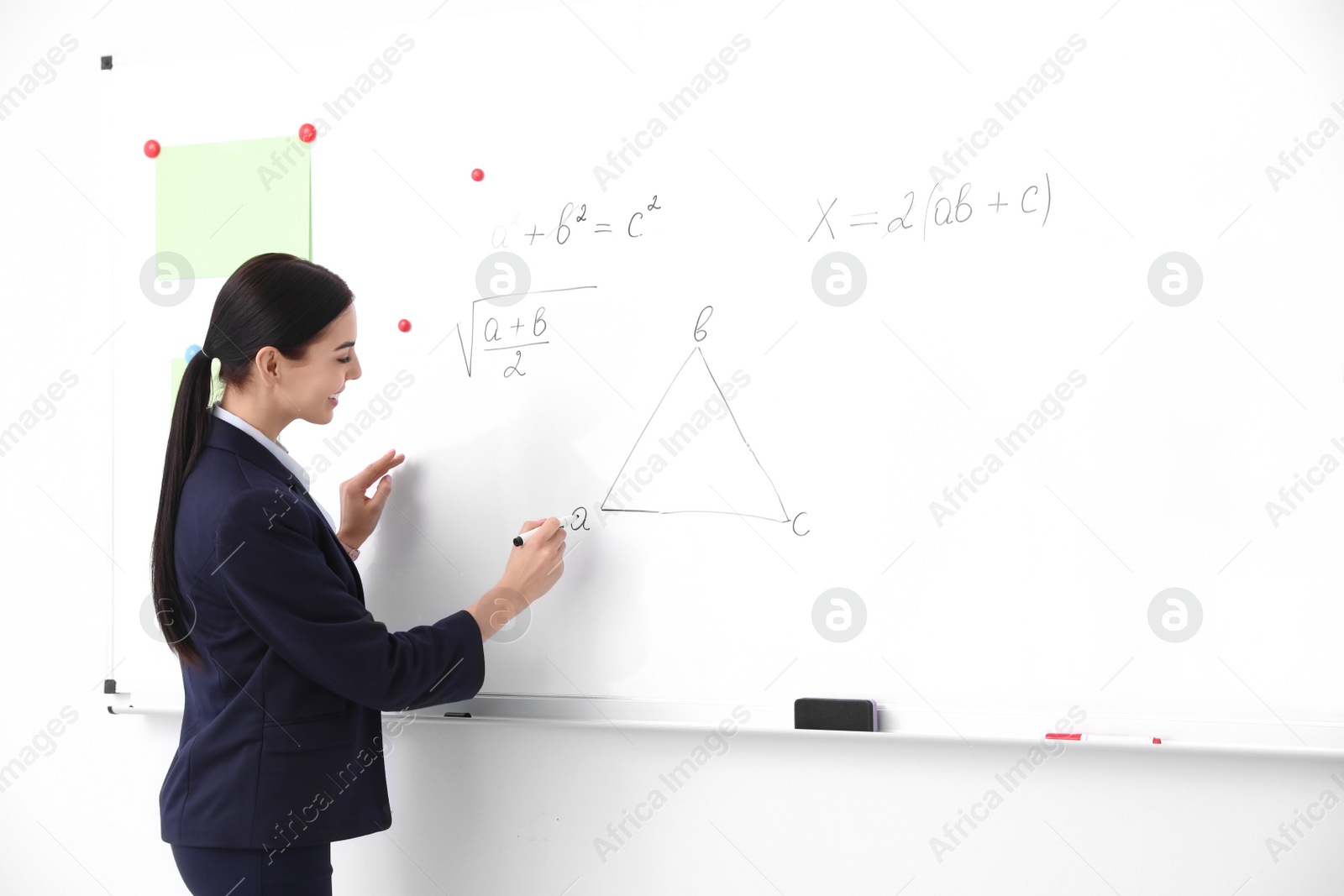 Photo of Young teacher near whiteboard in modern classroom