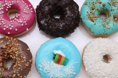 Photo of Different tasty glazed donuts on white background, closeup