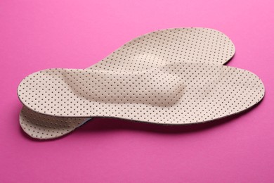 Photo of Orthopedic insoles on pink background, closeup. Foot care