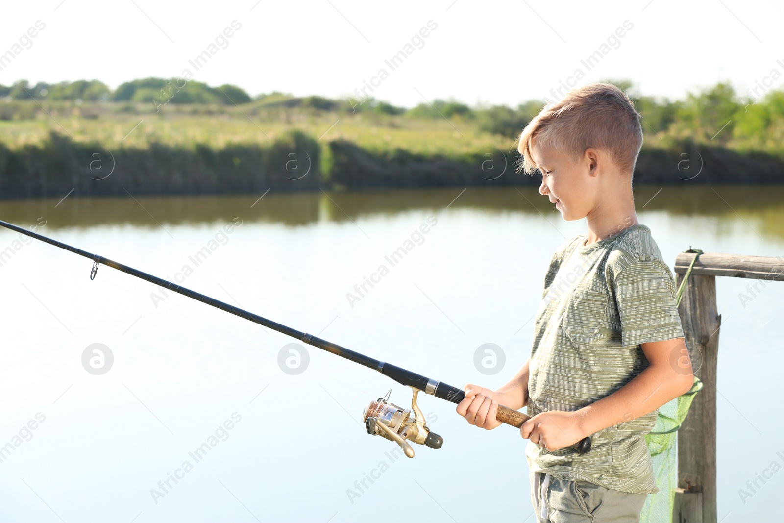 Photo of Little boy fishing alone on sunny day