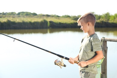 Little boy fishing alone on sunny day