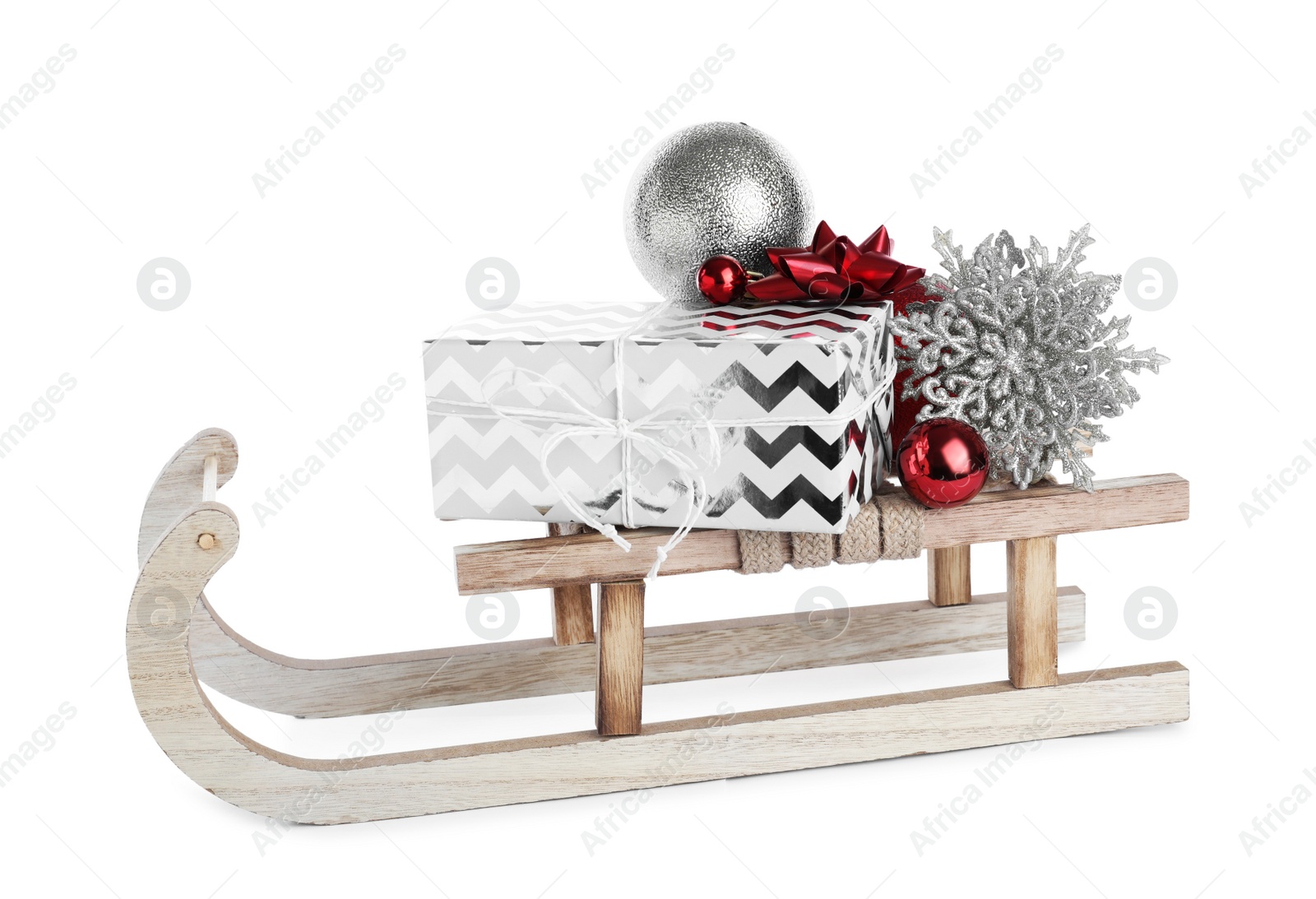Photo of Wooden sleigh with gift box and Christmas decorations isolated on white