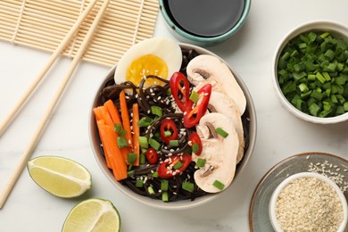 Photo of Flat lay composition with tasty buckwheat noodles (soba) and chopsticks on white marble table