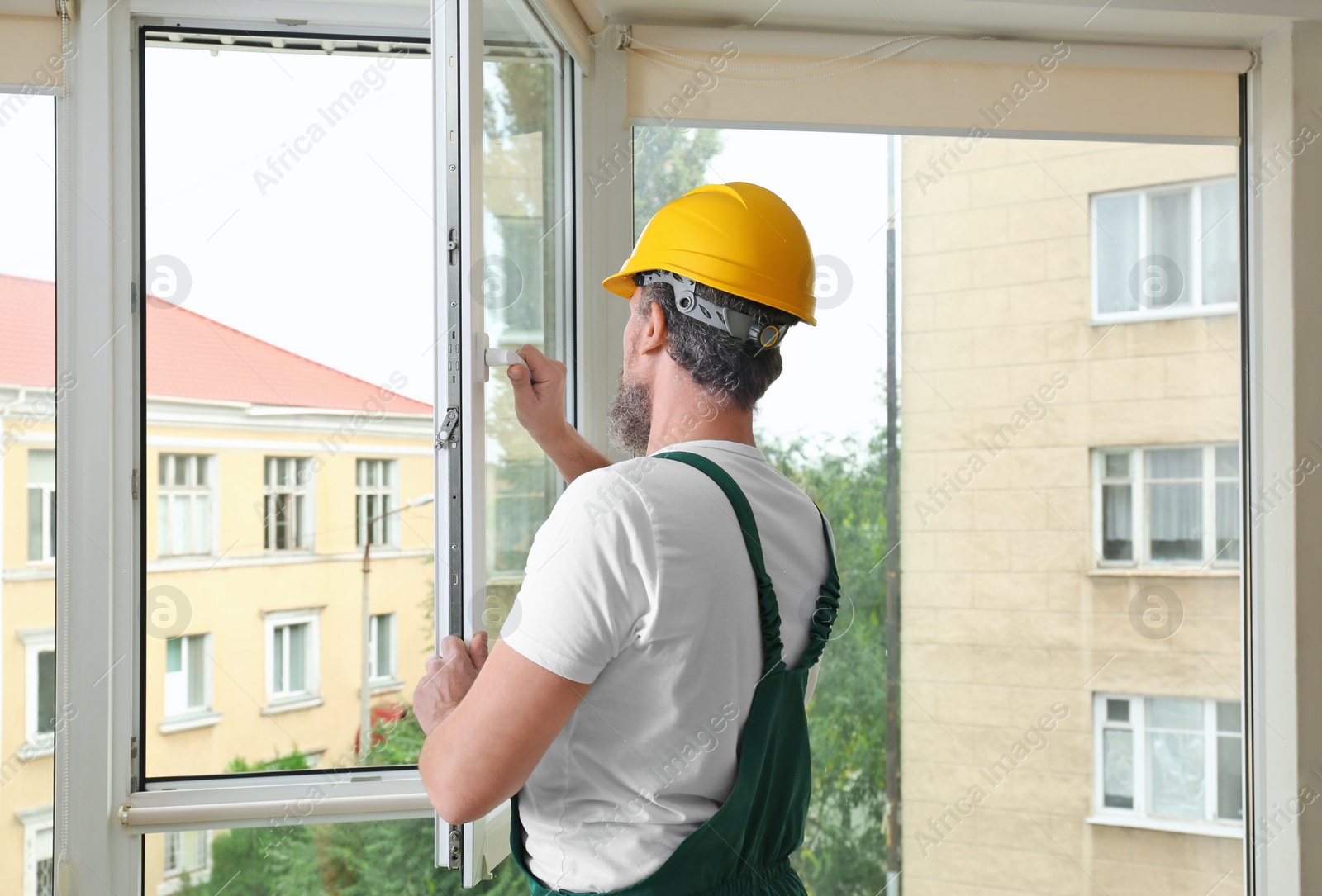 Photo of Construction worker installing new window in house